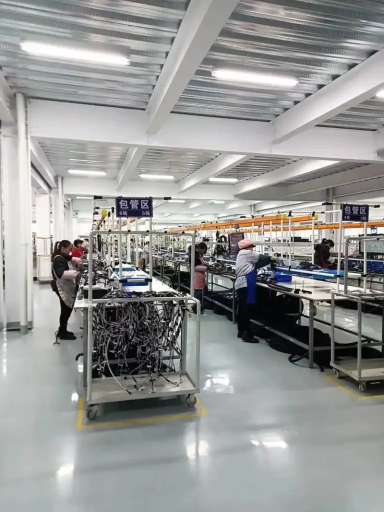 Nexharn cable factory production floor with workers at assembly and wiring stations