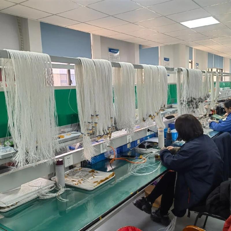 Workers operating wire cutting and cable assembly machines at Nexharn production line